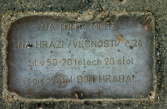Pamětní deska Bohumila Hrabala na asfaltu na místě domu Na Hrázi v Libni